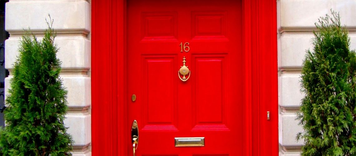 Red front door fitted with door furniture