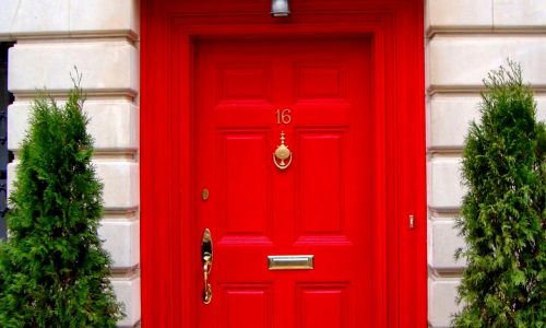 Red front door fitted with door furniture